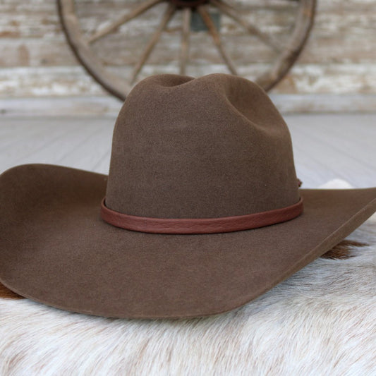 a brown hat on a white fur surface
