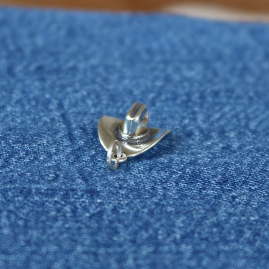 a silver hat on a blue fabric
