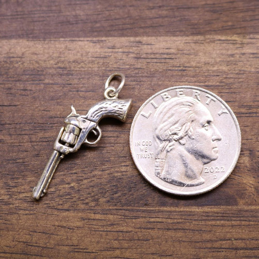 a coin and a gun pendant