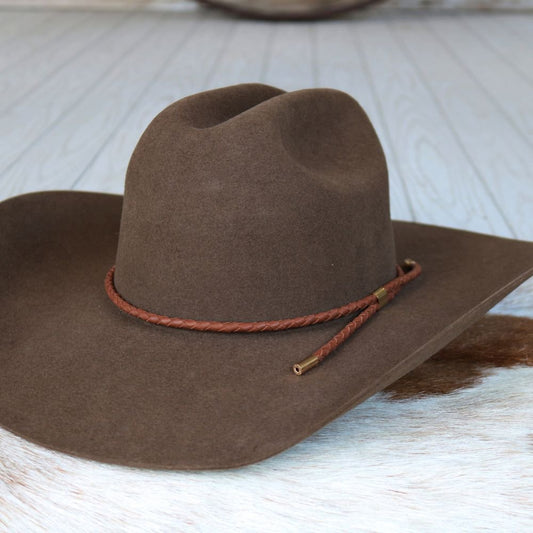 a brown cowboy hat on a white surface