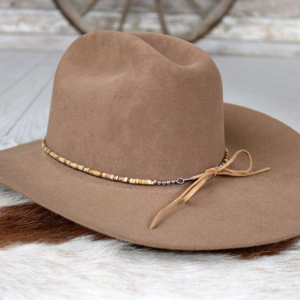 a brown hat on a white fur surface