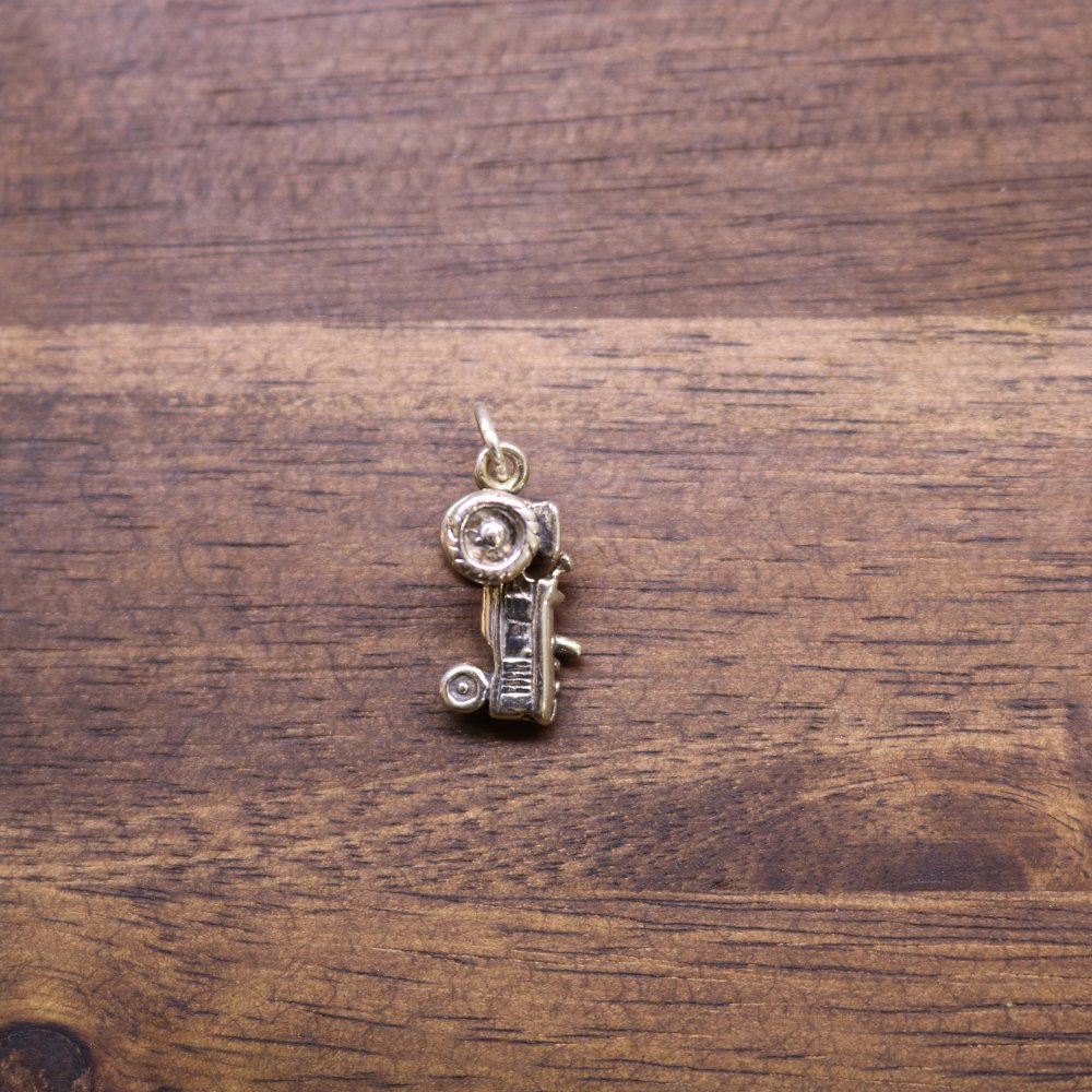 a gold pendant on a wood surface