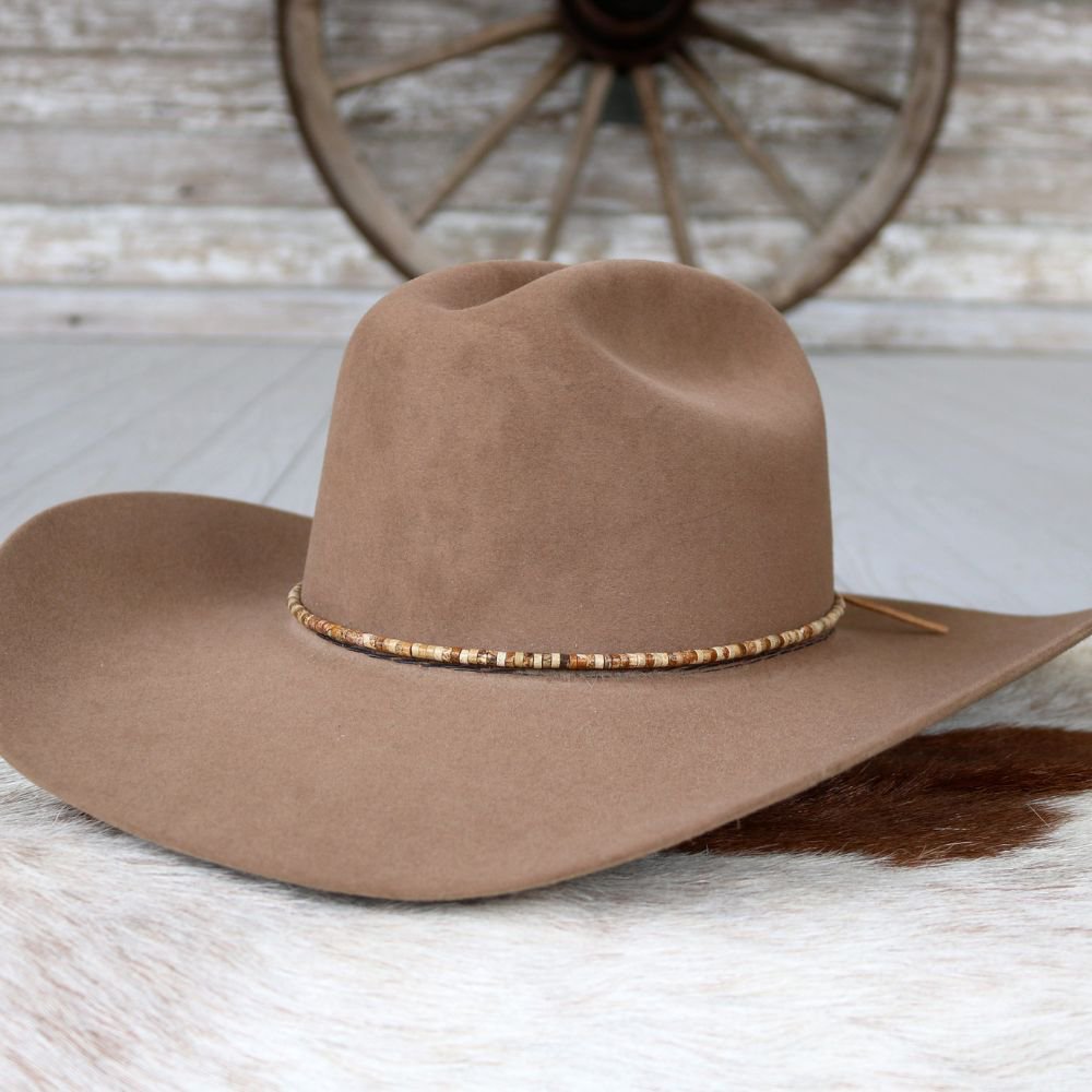 a brown hat on a white fur surface