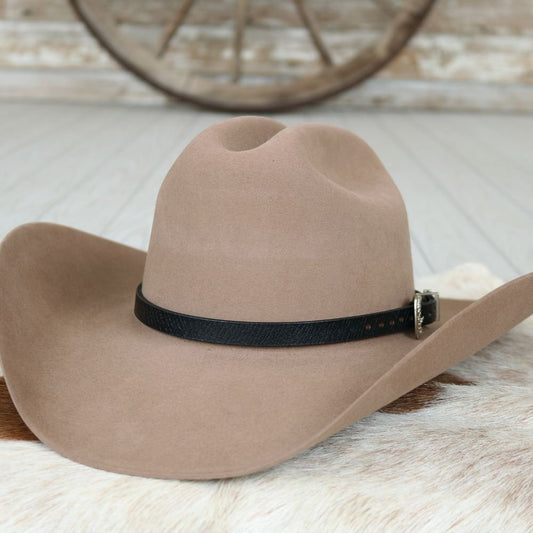 a brown cowboy hat on a white fur rug