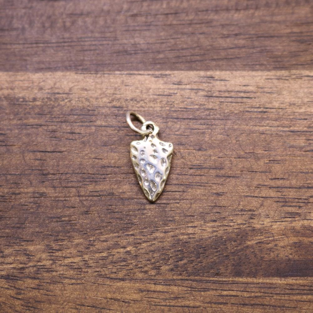 a gold metal object on a wood surface