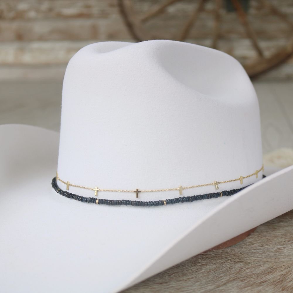 a white cowboy hat with gold and black beads