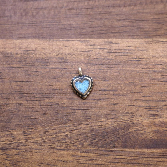 a heart shaped pendant on a wood surface