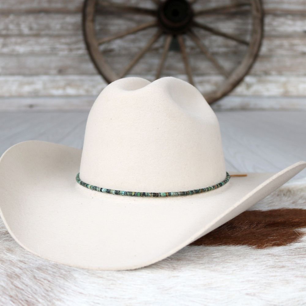 a white cowboy hat on a cowhide rug