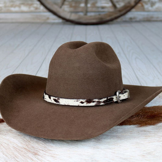 a brown hat on a white fur rug