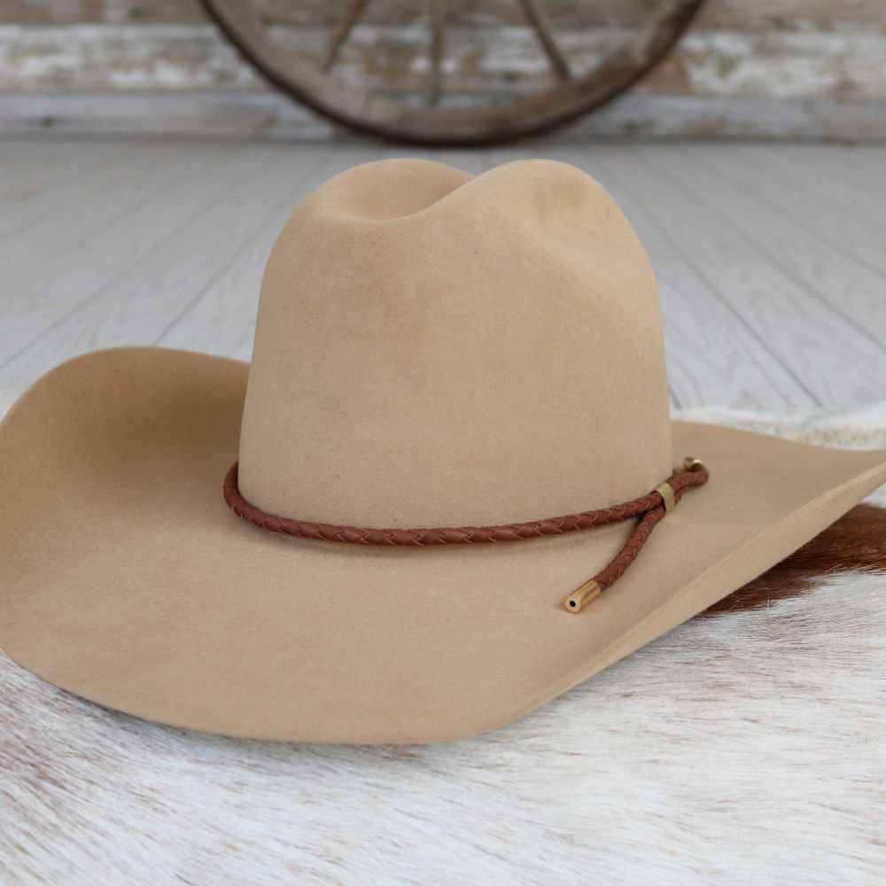 a brown cowboy hat on a white fur rug