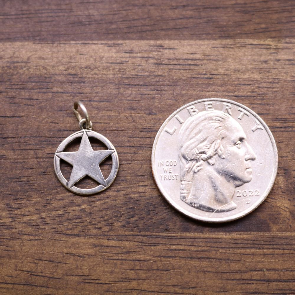 a coin and a pendant on a wood surface