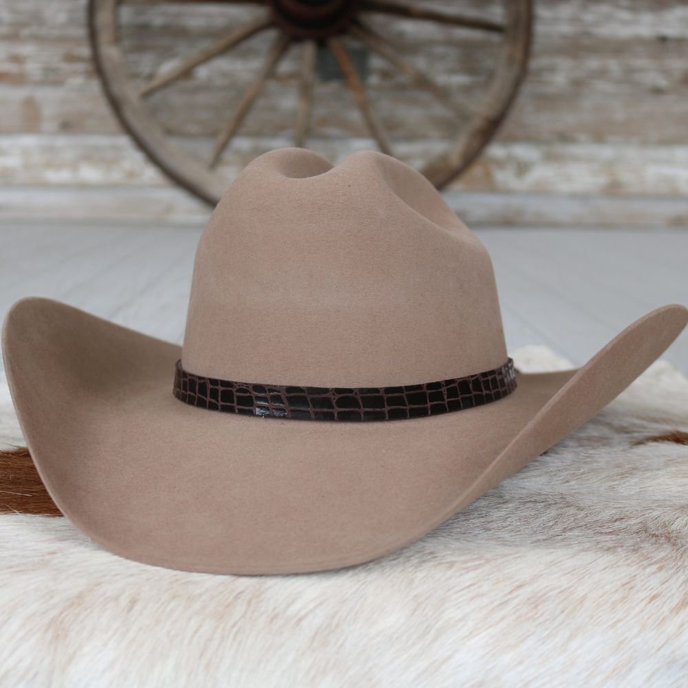 a brown cowboy hat on a white fur rug