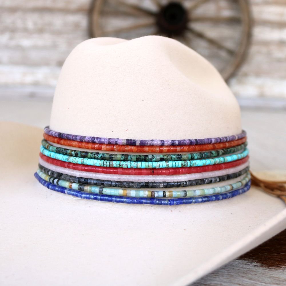 a white hat with multi colored beads on it