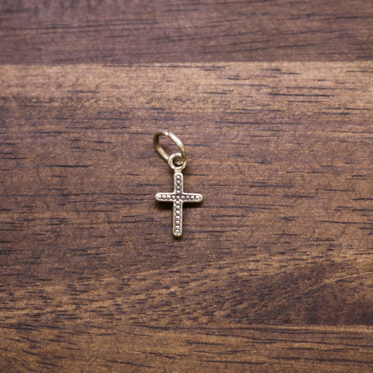 a gold cross on a wood surface