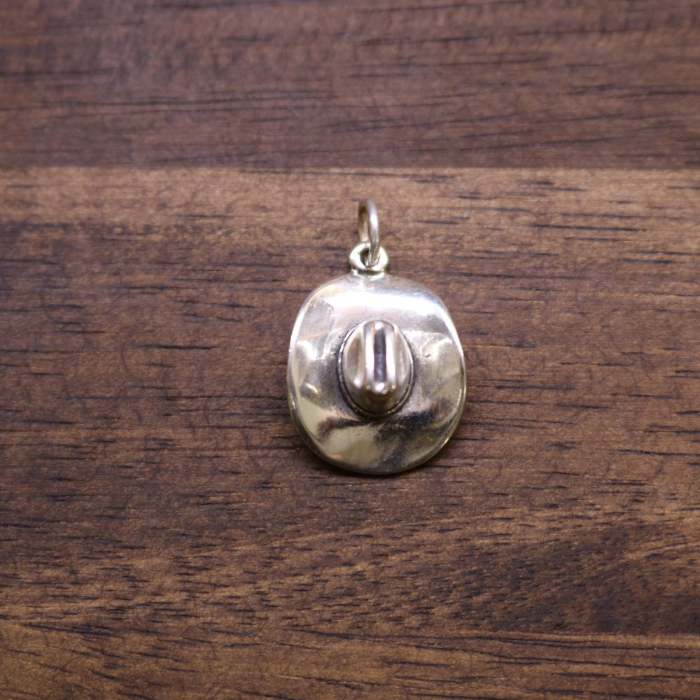 a silver pendant on a wood surface