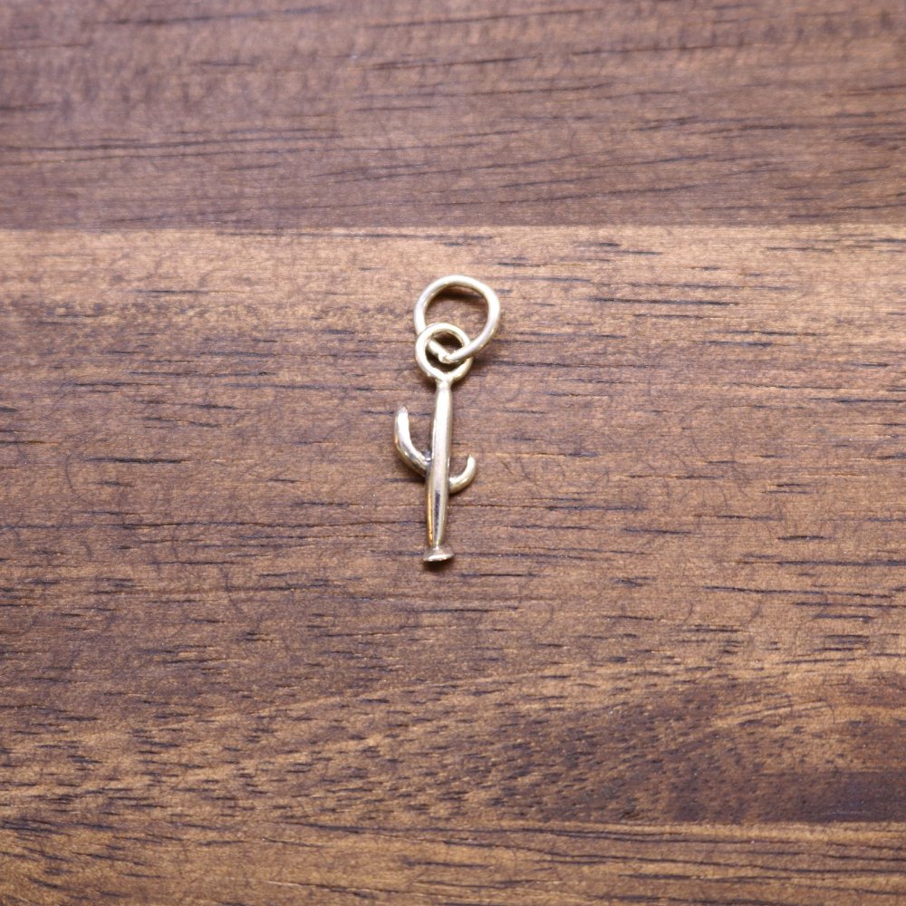 a gold metal keychain on a wood surface