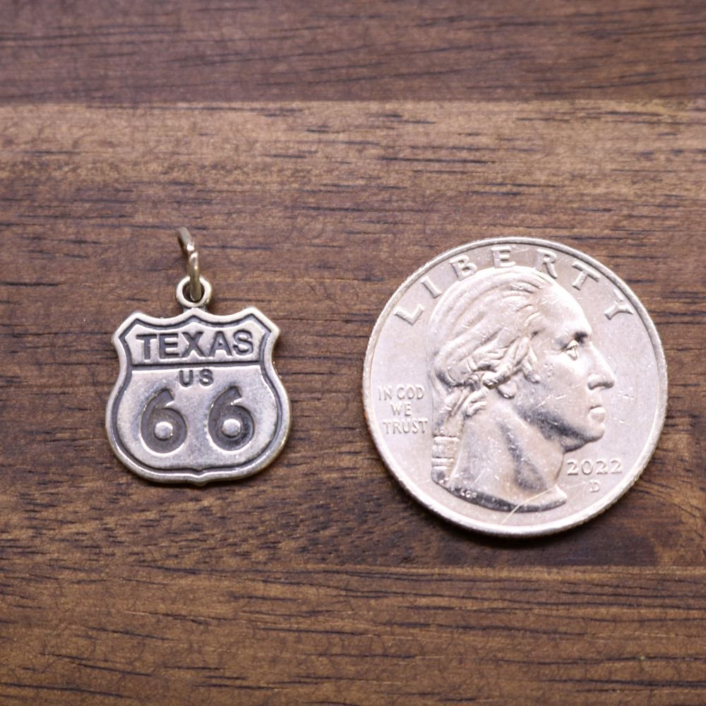 a coin and a pendant on a wood surface