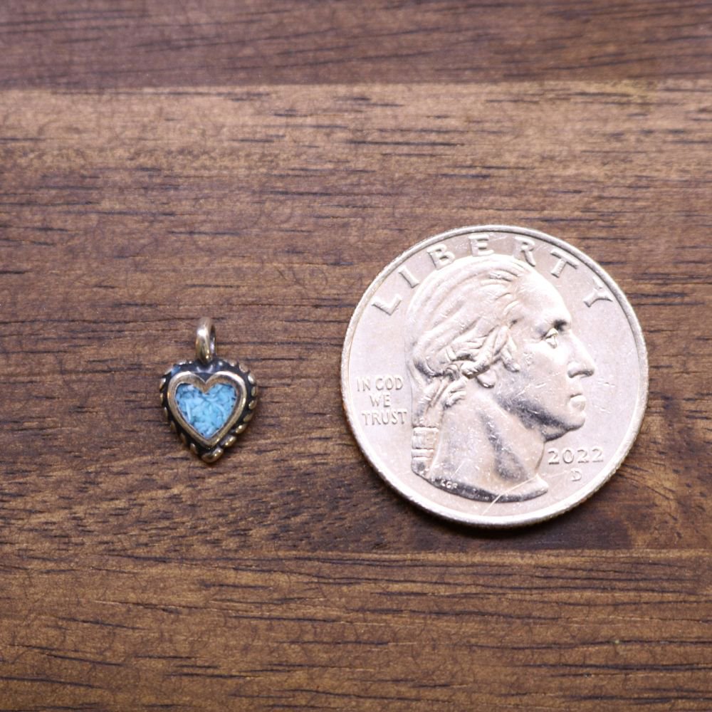 a coin and a heart shaped pendant