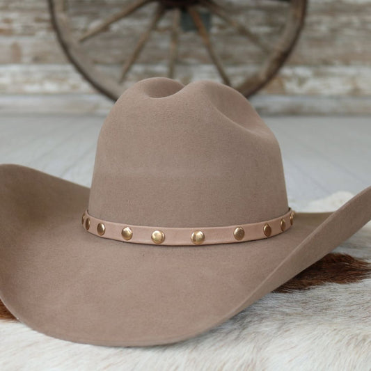 a brown cowboy hat on a white fur rug