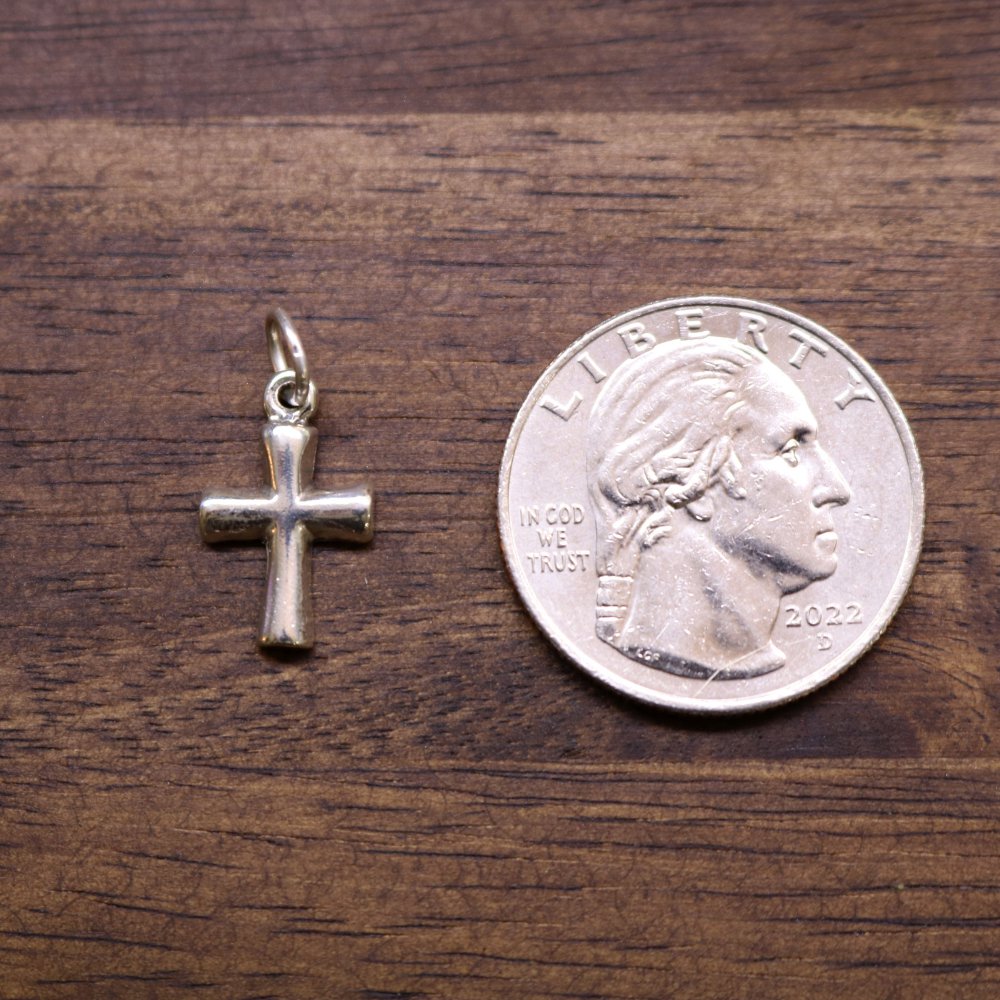 a coin and a cross on a wood surface