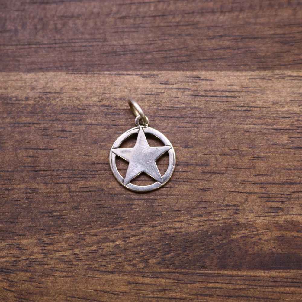 a silver star pendant on a wood surface