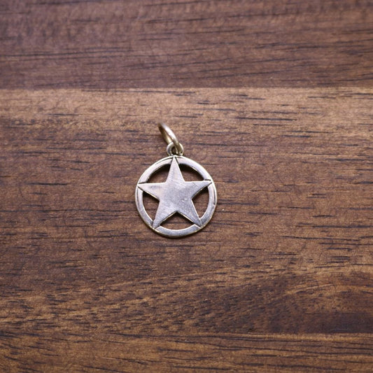 a silver star pendant on a wood surface