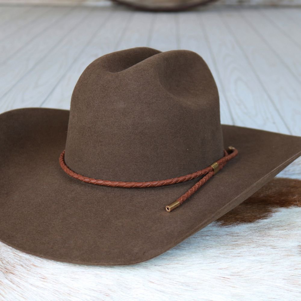 a brown cowboy hat on a white surface